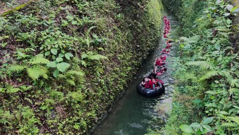 Eine-Gruppe-Von-Body-Rafting-Teilnehmern-Trägt-Schwimmwesten-Und-Schwimmt-Gemeinsam-In-Einer-Reihe-Auf-Dem-Gebirgsfluss