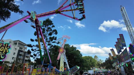 Large-crowd-attending-at-Paniyiri-Greek-Festival-in-Brisbane,-Australia-enjoying-thrill-riders