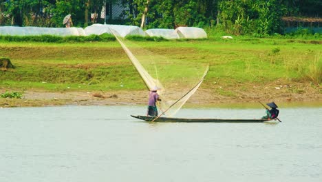 Pescadores-Asiáticos-En-Un-Barco-De-Madera-Haciendo-Pesca-Con-Red-Tradicional-En-Bangladesh