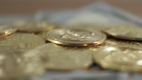 Goldene-Bitcoin-BTC-Münzen-Rotieren-über-Amerikanischen-Bargeld-Dollar-Papierscheinen,-Nahaufnahme-Im-Studio