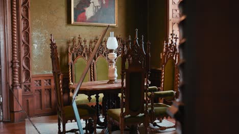 Small-Library-in-Trakošćan-Castle-,-Croatia,-featuring-ornate-wooden-chairs-and-a-table