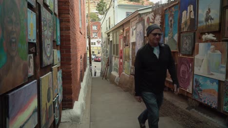 Tourist-and-his-dog-walking-up-the-Broadway-stairs,-pop-up-art-gallery,-in-Bisbee