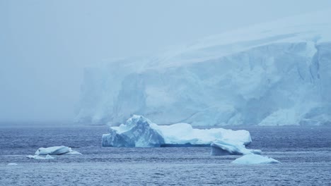 Paisaje-Glaciar-Invernal-De-La-Antártida-Con-Icebergs-En-La-Costa-En-Un-Paisaje-Azul-Frío-De-La-Península-Antártica-Con-Nieve-Nevada,-Hielo-Y-Glaciar-En-Una-Espectacular-Y-Hermosa-Escena-Costera-Con-Agua-De-Mar-Oceánica