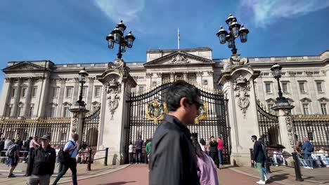 An-Einem-Sonnigen-Morgen-In-London,-England,-Schlendern-Menschen-Vor-Den-Toren-Des-Buckingham-Palace-Und-Fangen-Das-Pulsierende-Stadtleben-Und-Den-Reiz-Berühmter-Wahrzeichen-Ein