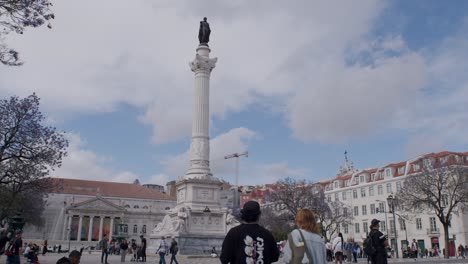 Vista-De-Perfil-De-La-Praca-Dom-Pedro-IV-En-Lisboa,-Portugal,-Llena-De-Turistas-Durante-El-Día.