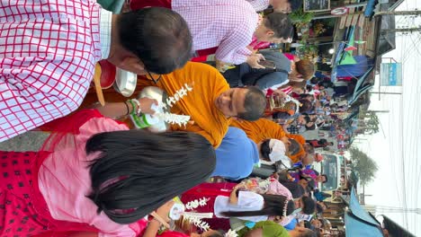 Vertical-view-of-Buddhist-monks-and-a-group-of-people-performing-a-ritual-of-giving-and-receiving-as-a-tradition-in-Thailand,-POV-shot