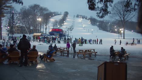 Ski-Resort-Public-Area-Reveal-Behind-Tree-at-Twilight,-Boyne-Mountain-MI
