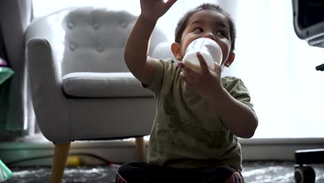 18-Monate-Alter-Junge-Trinkt-Milch,-Während-Er-Zu-Hause-Auf-Dem-Boden-Sitzt