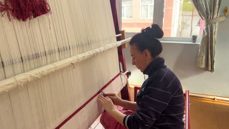 Telar-Para-Tejer-Alfombras-A-Mano-Con-Una-Mujer-Trabajando-Detrás-Del-Escenario