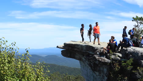 People-enjoying-the-view-from-atop-McAfee-Knob-in-Virginia,-some-people-relaxing-and-eating-lunch-after-the-hike-up-the-Appalachian-Trail