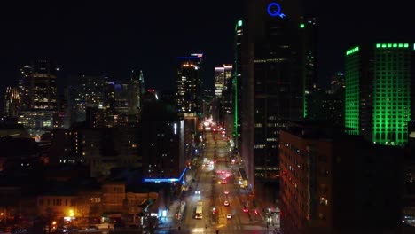 Hydro-Quebec-Building-Headlining-Night-Sky-Alongside-Green-Buildings