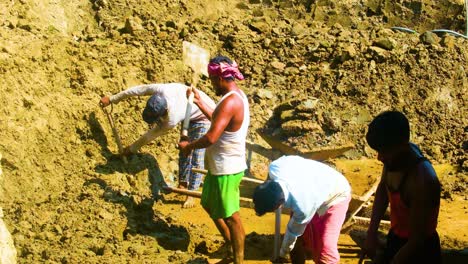 Harte-Arbeiter-Mit-Einer-Gruppe-Von-Männern-Schaufeln-Schlamm-Lehm-Auf-Dem-Feld-In-Bangladesch,-Asien