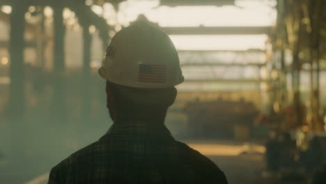 Bearded-man-wearing-a-hard-hat-walking-around-looking-at-his-work-site-outdoors