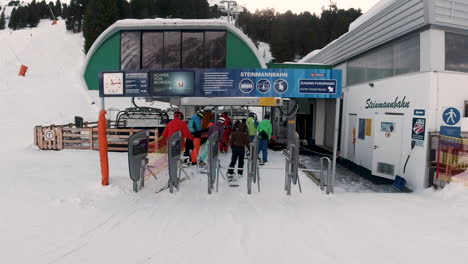 Group-of-skiers-getting-on-chair-ski-lift-in-Obergurgl-ski-resort,-Austria