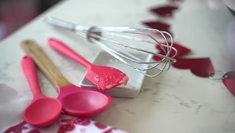 Slow-pan-of-strawberries-and-silicone-spoons-making-a-special-valentine's-day-cake-vegan-chocolate-cake-eggless-plant-based-dairy-free