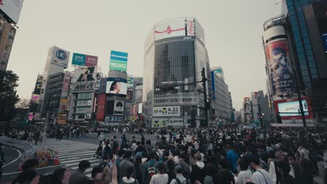 Multitud-De-Peatones-Cruzando-La-Intersección-De-Shibuya-En-Tokio,-Japón---Plano-Amplio