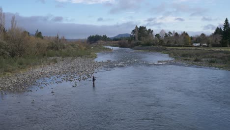 Pescador-Pescando-Truchas-En-Un-Río-Tranquilo-Durante-El-Invierno-En-Turangi,-Nueva-Zelanda