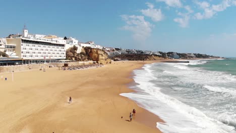 People-strolling-along-pristine-Albuferia-sand-beach,-Algarve