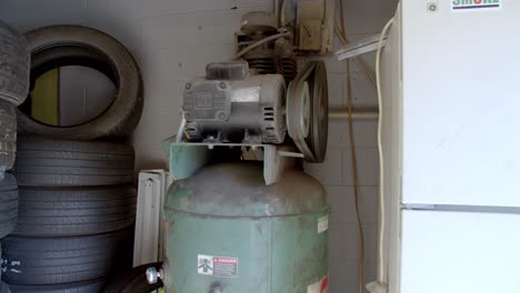 Lockdown-shot-of-air-compressor-and-rack-of-old-tires