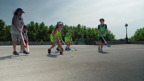 Low-angle-shot-of-young-children-playing-hockey-on-a-beautiful-summers-day