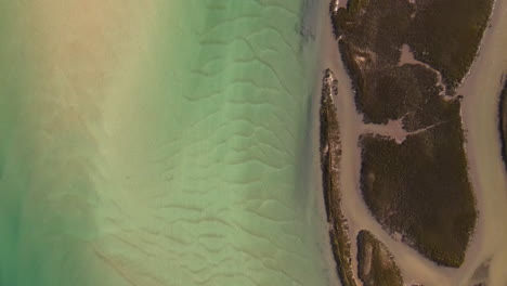 Agua-Azul-Clara-Y-Marisma-Del-Estuario-De-Goukou-En-La-Bahía-Quieta,-Drone-De-Arriba-Hacia-Abajo