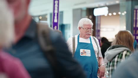 Two-Men-Volunteers-Talking-at-a-Used-Library-Book-Sale-in-a-Mall