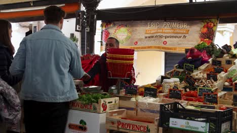 Vibrant-outdoor-market-scene-in-Antibes,-France-with-shoppers-browsing-fresh-produce