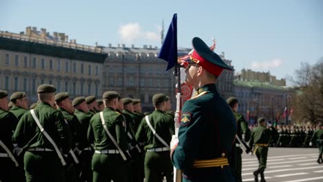 Soldiers-march-in-formation-at-a-ceremony-and-a-flag-standing