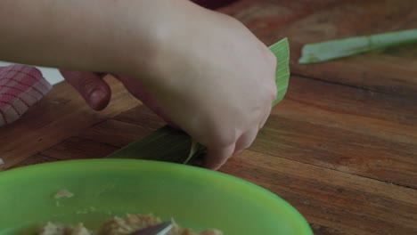 Las-Manos-Moldean-Carne-Picada-Dentro-De-Hojas-De-Plátano,-Elaborando-El-Manjar-Balinés,-Sate-Lilit.