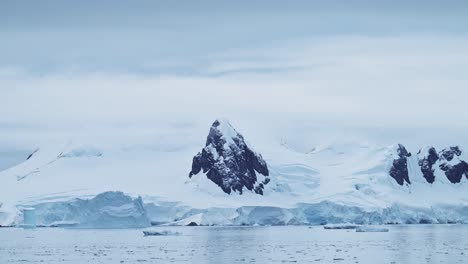 Antarctica-Winter-Mountains-on-Coast,-Coastal-Landscape-Scenery-in-Antarctic-Peninsula,-Cold-Blue-Scene-with-Glacier-Ice-and-Southern-Ocean-Sea-Water,-Mountain-Seascape-in-Beautiful-Dramatic-Scene