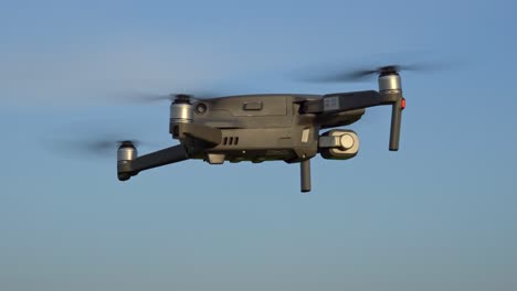 Drone-in-Flight-Hovering-Against-Blue-Sky,-Static-Closeup