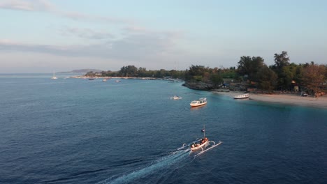 Luftaufnahme-Eines-Bootes-Mit-Touristen,-Die-Sich-Der-Küste-Einer-Kleinen-Tropischen-Insel-Im-Bali-Archipel-Nähern