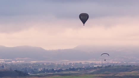 Temecula-Ballon--Und-Weinfest,-Drohnenansicht-Des-Pala-Heißluftballons-Und-Eines-Gleitschirms