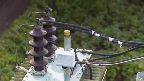 Close-up-of-aged-transformer-equipment-with-cables-and-ceramic-insulators