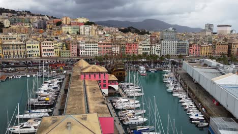 Genoa's-colorful-cityscape-and-busy-port-against-a-cloudy-backdrop,-aerial-view