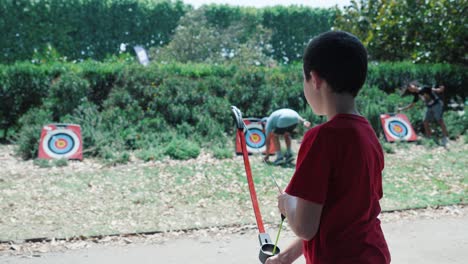 Slow-motion-shot-of-a-young-boy-firing-a-plastic-sucker-arrow-at-a-target