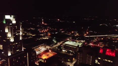 Centro-Nocturno-De-Raleigh-Carolina-Del-Norte-Horizonte-Drone-Pan-Izquierda