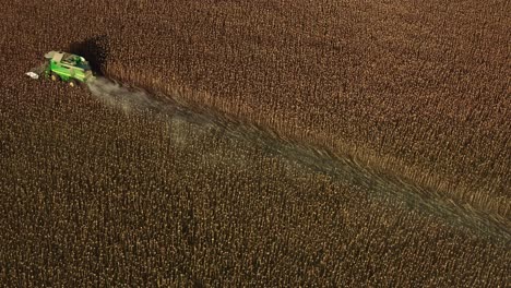 Toma-Aérea-De-Un-Drone-De-Un-Tractor-Cosechador-John-Deere-Cosechando-Semillas-De-Girasol-Durante-Las-Noches-De-Verano-En-Bulgaria