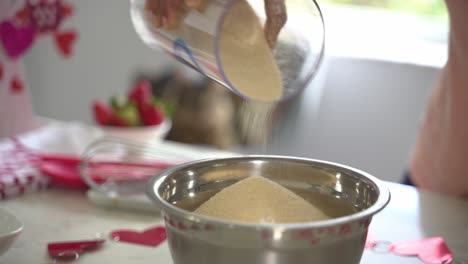 Schöner-Winkel,-In-Dem-Brauner-Zucker-In-Eine-Schüssel-Mit-Mehl-Gegossen-Wird,-Um-Einen-Besonderen-Valentinstagskuchen-Zuzubereiten,-Veganer-Schokoladenkuchen,-Eifrei,-Pflanzlich-Und-Milchfrei