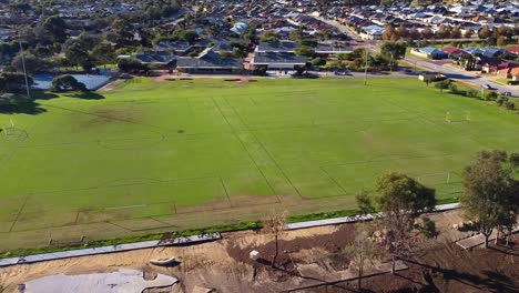 Aerial-orbit-revealing-football-pitches-on-sunny-day,-Riverlinks-Park-Clarkson