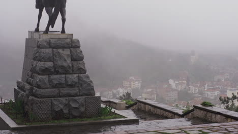 4K-Aufnahmen-Eines-Denkmals-Auf-Dem-Gipfel-Des-Berges-Stara-Planina-In-Vratsa,-Bulgarien,-Während-Dichter-Nebel-Die-Stadt-Bedeckt