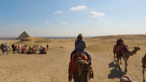 POV-De-Una-Persona-Montada-En-Camello-A-Través-Del-Desierto-Abierto-Con-Una-Pirámide-En-La-Distancia