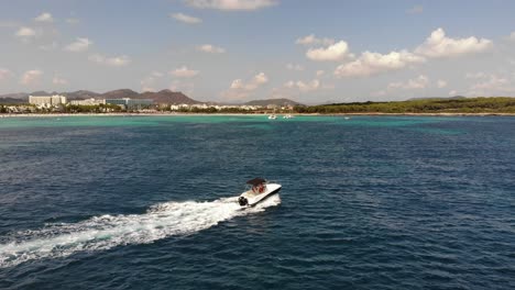 Tracking-aerial-follows-motorboat-in-clear-water-off-Mallorca-beach