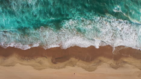 Top-View-Of-Ocean-Waves-Splashing-On-Sandy-Shore