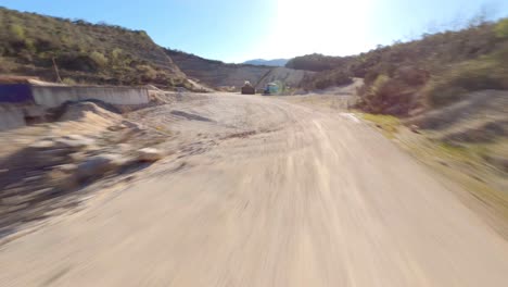 Mit-Einer-FPV-Drohne-Durch-Einen-Bulldozer-Und-Einen-LKW-In-Einem-Verlassenen-Steinbruch-Fliegen