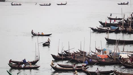 Traditional-passenger-boats-leaving-and-anchoring-at-the-port-in-Buriganga-River,-Sadarghat,-Dhaka,-Bangladesh