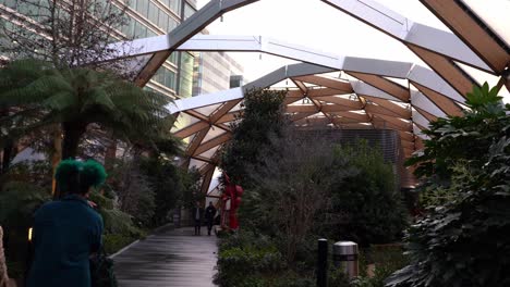 POV-walking-behind-two-girls-exploring-indoor-park-at-Canary-Wharf,-London