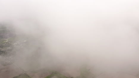 Aerial-drone-moves-through-clouds-above-grassland-and-farmland-in-midwest-of-United-States