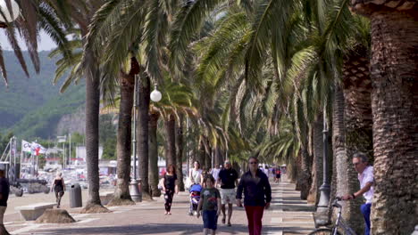 People-walking-over-path-near-harbor-in-La-Spezia,-Italy