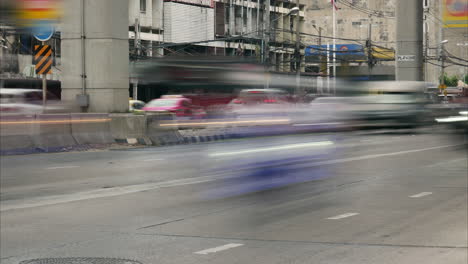 Time-lapse-of-cars-traveling-in-the-city-under-the-MRT-track-in-Bangkok,-Thailand